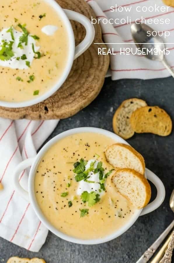 Looking down on two bowls of Slow Cooker Broccoli Cheese Soup served with slices of toasted bread