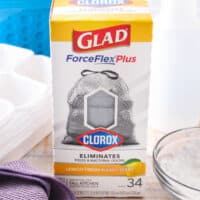 box of Glad® ForceFlexPlus with Clorox™ trash bags next to bins and cleaning supplies with post name at the bottom