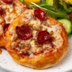 close up square image of air fryer biscuit pizzas on a plate with a salad