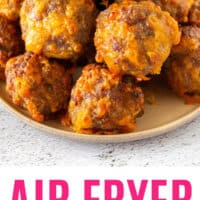 air fryer cheddar & sausage balls piled on a plate with recipe name at the bottom