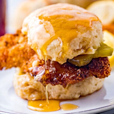 square image of a air fryer chicken biscuit sandwich drizzled with honey