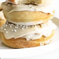 three air fryer coffee donuts stacked up with a bite taken out of the top donut with recipe name at the bottom