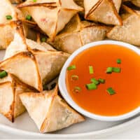 air fryer crab rangoon on a plate with a bowl of duck sauce with recipe name at the bottom
