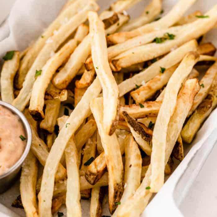 square image of air fryer french fries in piled up in a basket