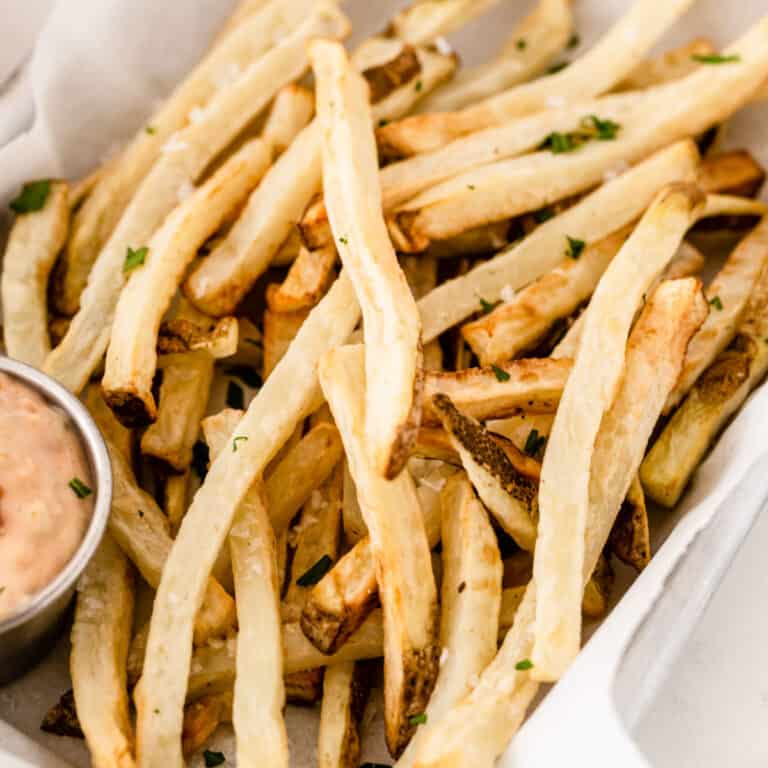 square image of air fryer french fries in piled up in a basket