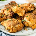 square image of air fryer fried chicken piled onto a serving plate