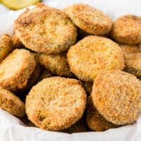 square image of air fryer fried pickles in a bowl with parchment paper
