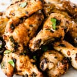 square image of air fryer garlic parmesan chicken wings piled on a plate