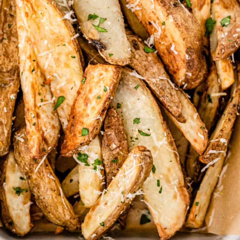 square image of air fryer garlic parmesan potato wedges piled up together