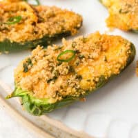 close up of air fryer jalapeno poppers on a platter with recipe name at the bottom