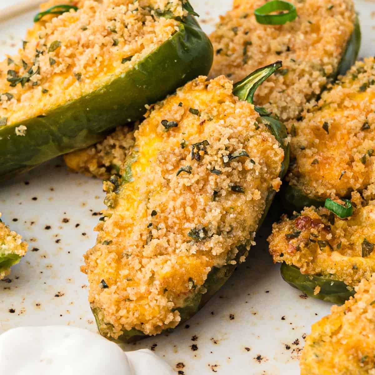 square image close up of air fryer jalapeno poppers on a plate