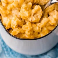 spoon in a bowl of air fryer mac and cheese with recipe name at the bottom