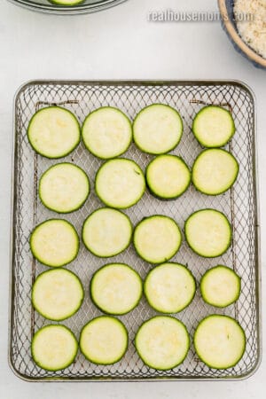 zucchini slices arranged in a single layer in an air fryer basket