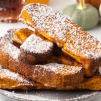 square image of air fryer pumpkin french toast sticks with powdered sugar