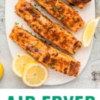 air fryer salmon filets on a platter with lemon wedges with recipe name at the bottom