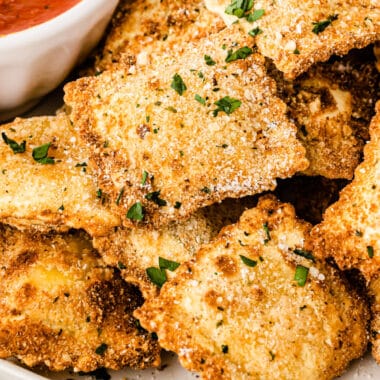 square image of air fryer toasted ravioli topped with parmesan and chopped parsley