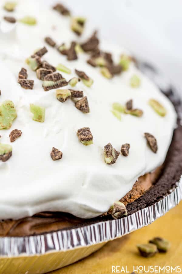 Whole Andes Mint Pie topped with whipped topping and Andes candy pieces