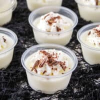 square image of whipped jello shots topped with whipped cream and chocolate