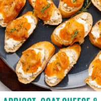apricot, goat cheese & caramelized onion crostini on a black serving plate with recipe name at the bottom