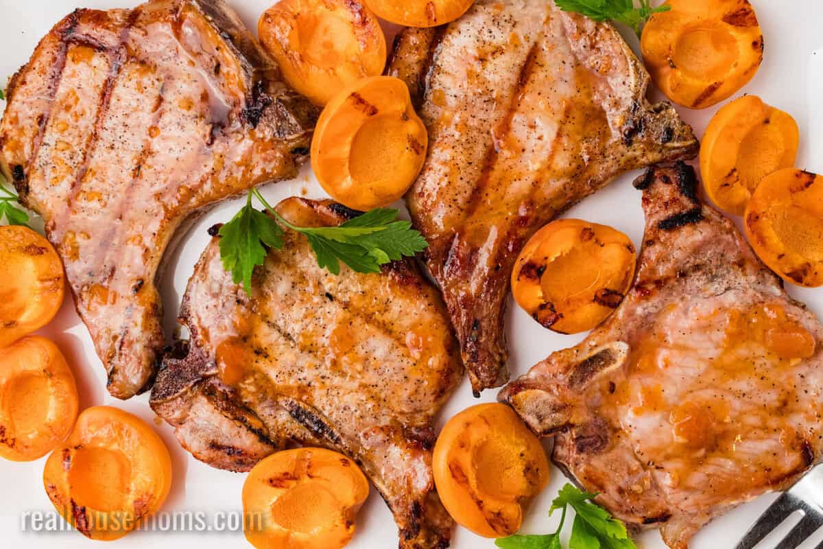 apricot grilled pork chops and grilled apricots on a platter with parsley