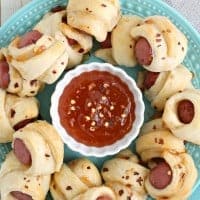 A childhood favorite gets a sweet & spicy makeover perfect for the adults in these Apricot Sriracha Pigs in a Blanket!