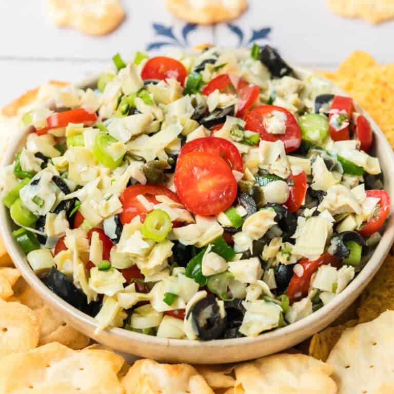 square image of a bowl full of artichoke salsa