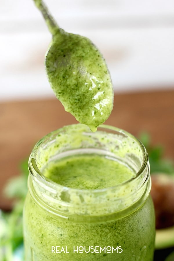 Spoon being lifted out of a jar of Avocado Cilantro Lime dressing