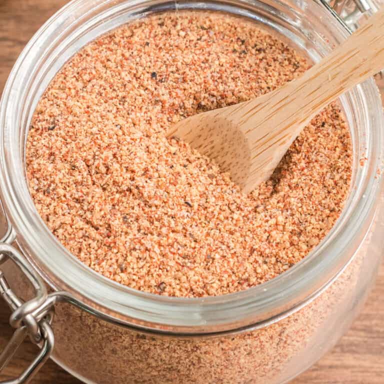 square image of bbq dry rub in a mason jar with a small wooden spoon