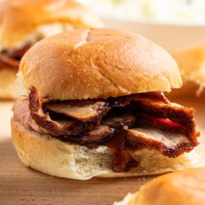 close up of a BBQ pork loin slider with sliced meat and BBQ sauce