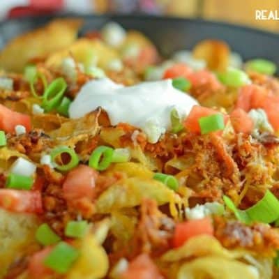 PULLED PORK POTATO CHIP NACHOS are a new twist on an old favorite! Crispy kettle chips, tangy BBQ & two cheeses make this is an appetizer everyone will enjoy!