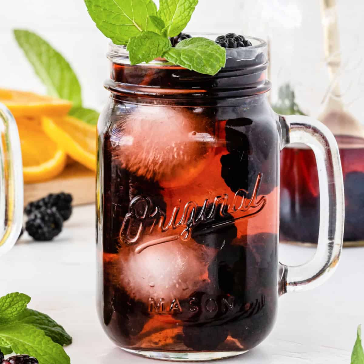square image of blackberry sangria in a mason jar glass with mint