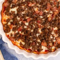 bacon & bison low carb pizza in the dish with recipe name at the bottom