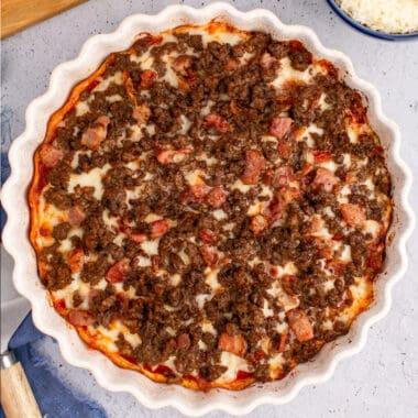square image of a bacon & bison low carb pizza in the dish