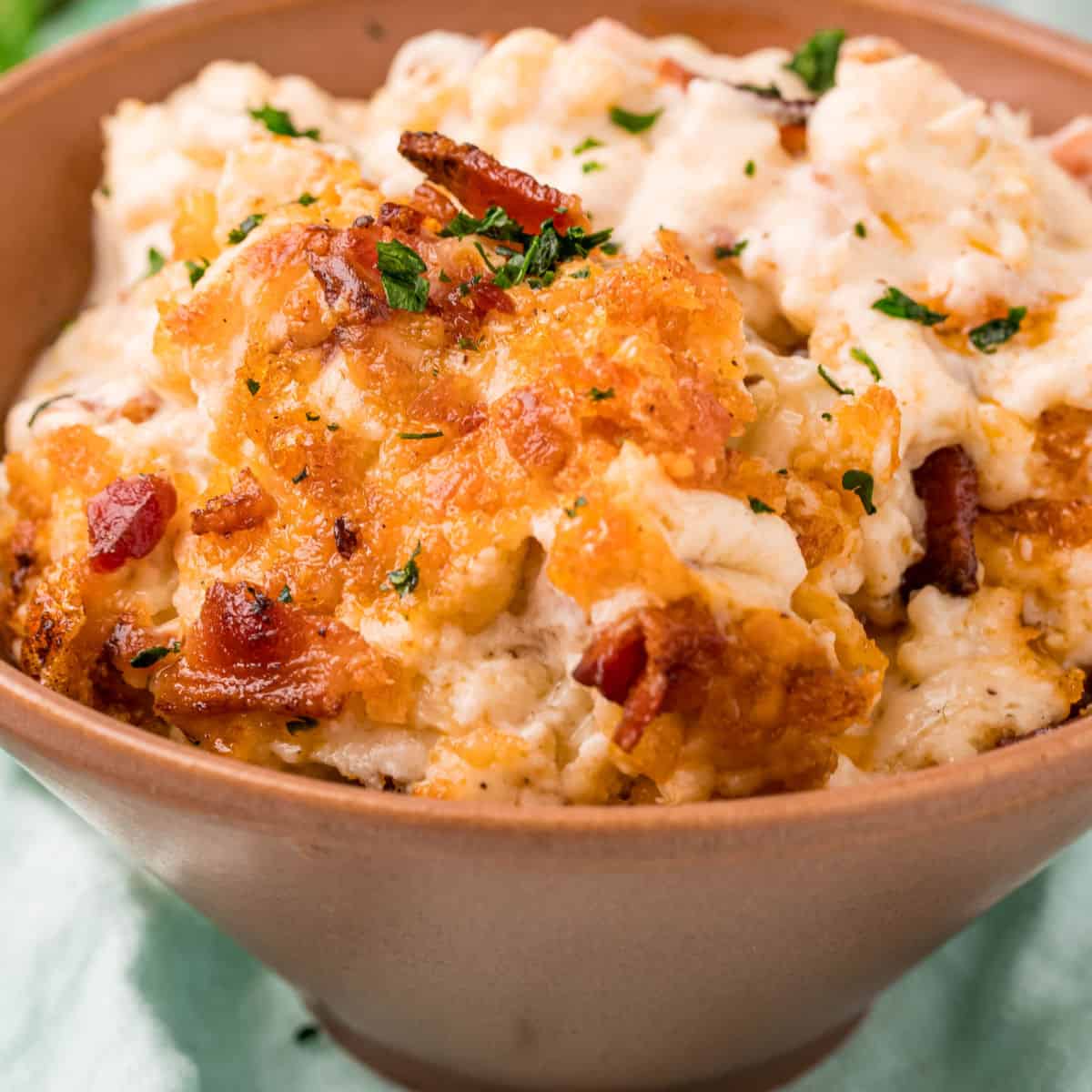 square image of bacon cauliflower mac and cheese in a bowl