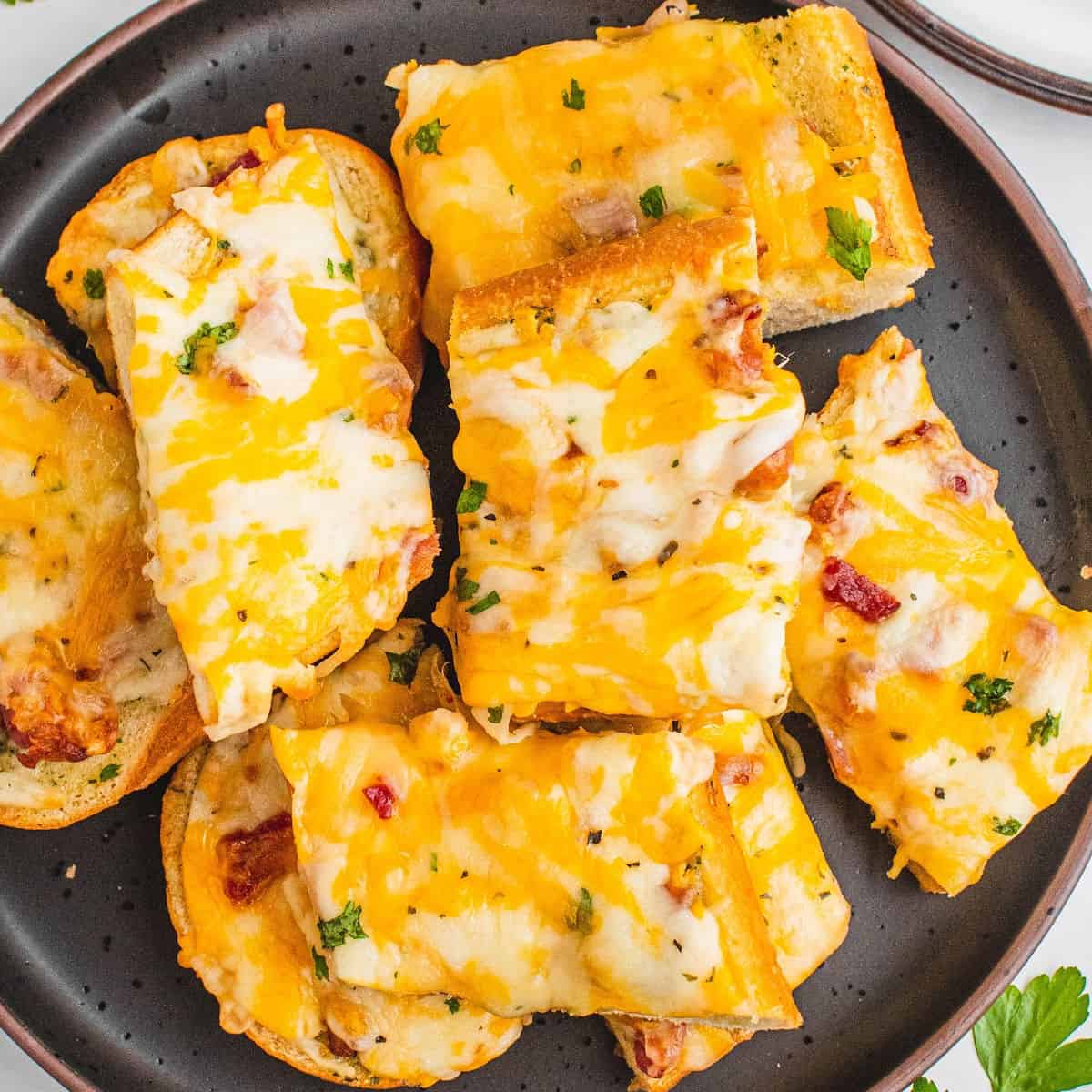 square image of bacon ranch cheese bread slices stacked on a plate