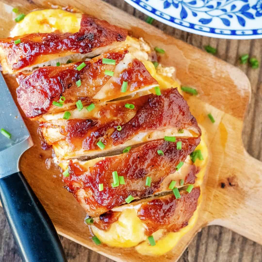 Bacon Wrapped Chicken slathered with sticky BBQ sauce & stuffed with gooey, melted cheese is an easy dinner idea that'll have everyone asking for seconds!