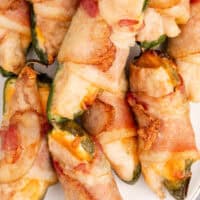 bacon wrapped chicken jalapeno poppers on a platter with recipe name at the bottom