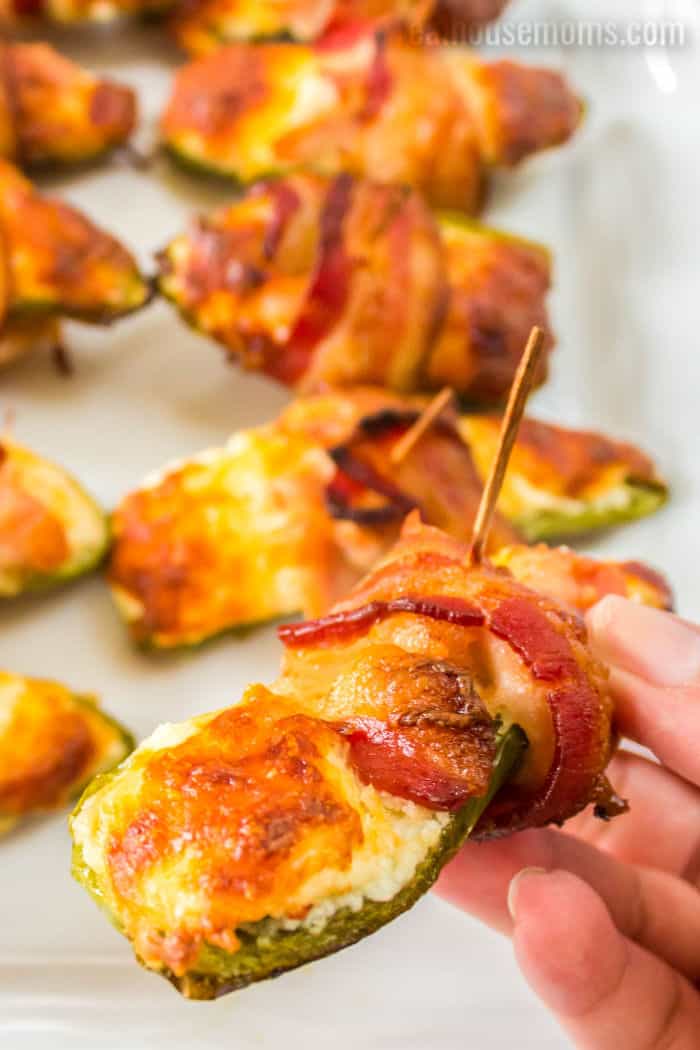hand holding a bacon wrapped chicken jalapeno popper