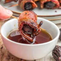 bacon wrapped fig being dipped into maple syrup with recipe name at the bottom