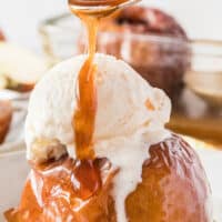 full image of a baked apple topped with vanilla ice cream in a bowl with a spoon dripping honey. pink and black lettering on top