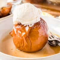 square image of a baked apple topped with vanilla ice cream in a bowl
