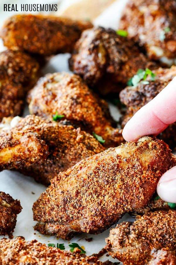 fingers picking up a baked chili rub wing