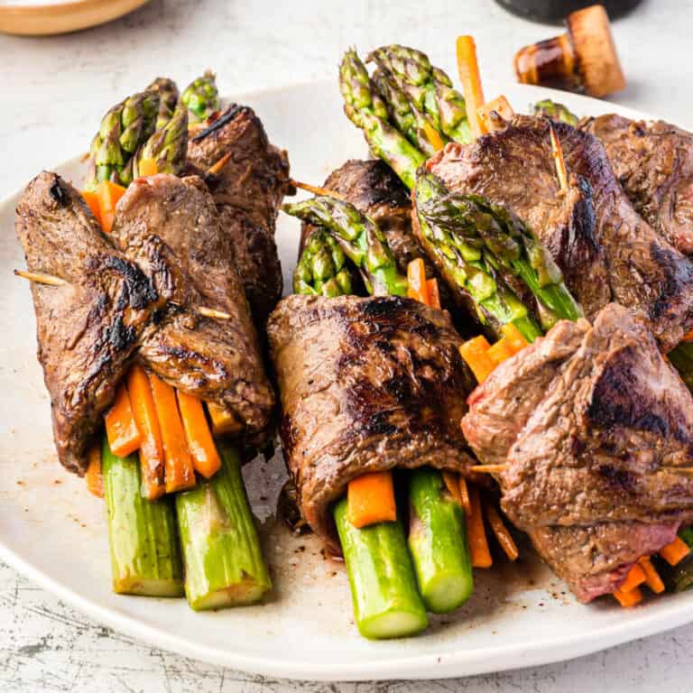 square image of balsamic steak roll ups on a plate