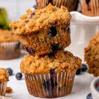 square image of two banana blueberry crumb muffins stacked on each other