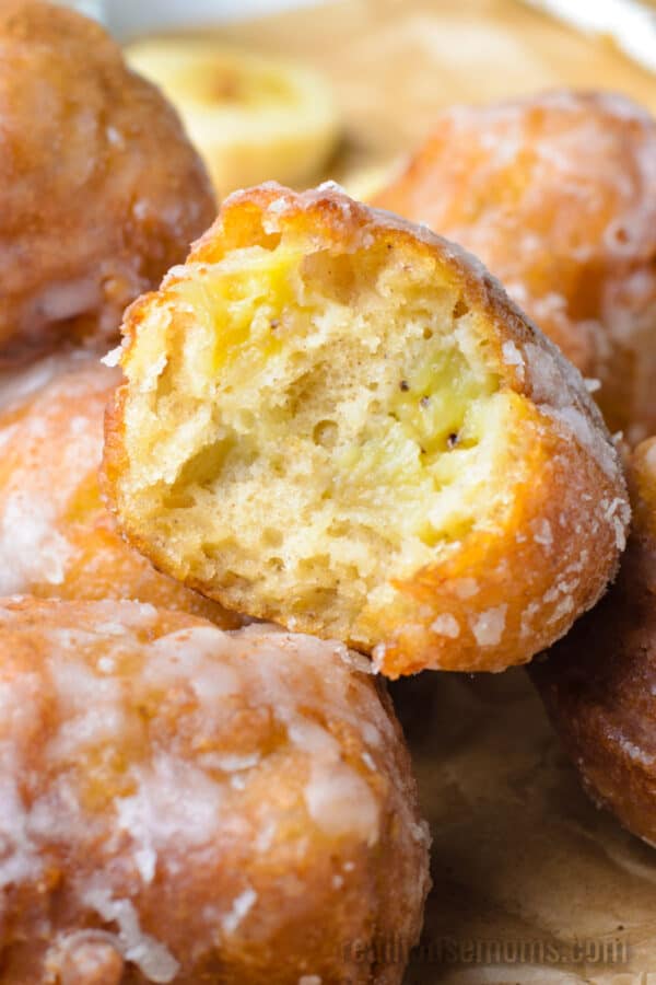 close up of a banana fritter with a bite taken out to show the inside
