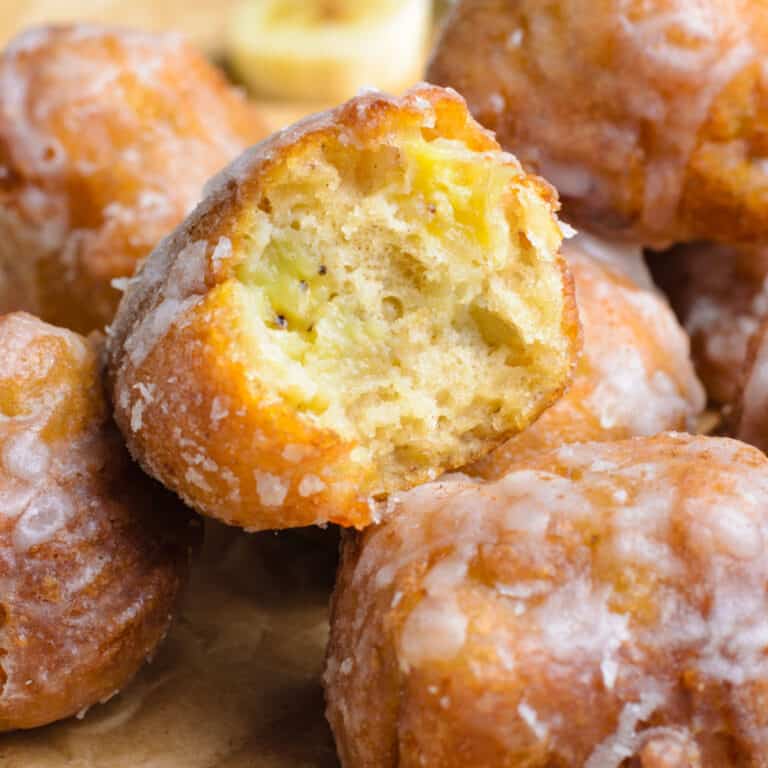 square image of banana fritters with a bite taken out of one