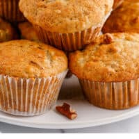 banana nut muffins piled up on a plate with recipe name at the bottom