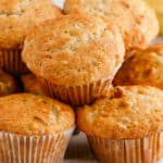 square image of banana nut muffins piled up on a plate
