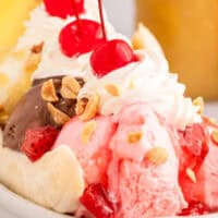 image of a banana split with sauces, whipped cream, cherries, and peanuts with the title of the post on top in blue and black lettering