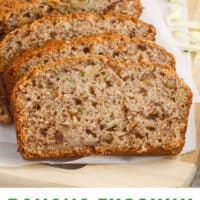banana zucchini bread cut into slices on a wooden board with recipe name at the bottom